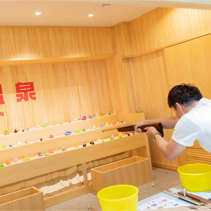 テルマエ射的で射的用の銃を構える男性